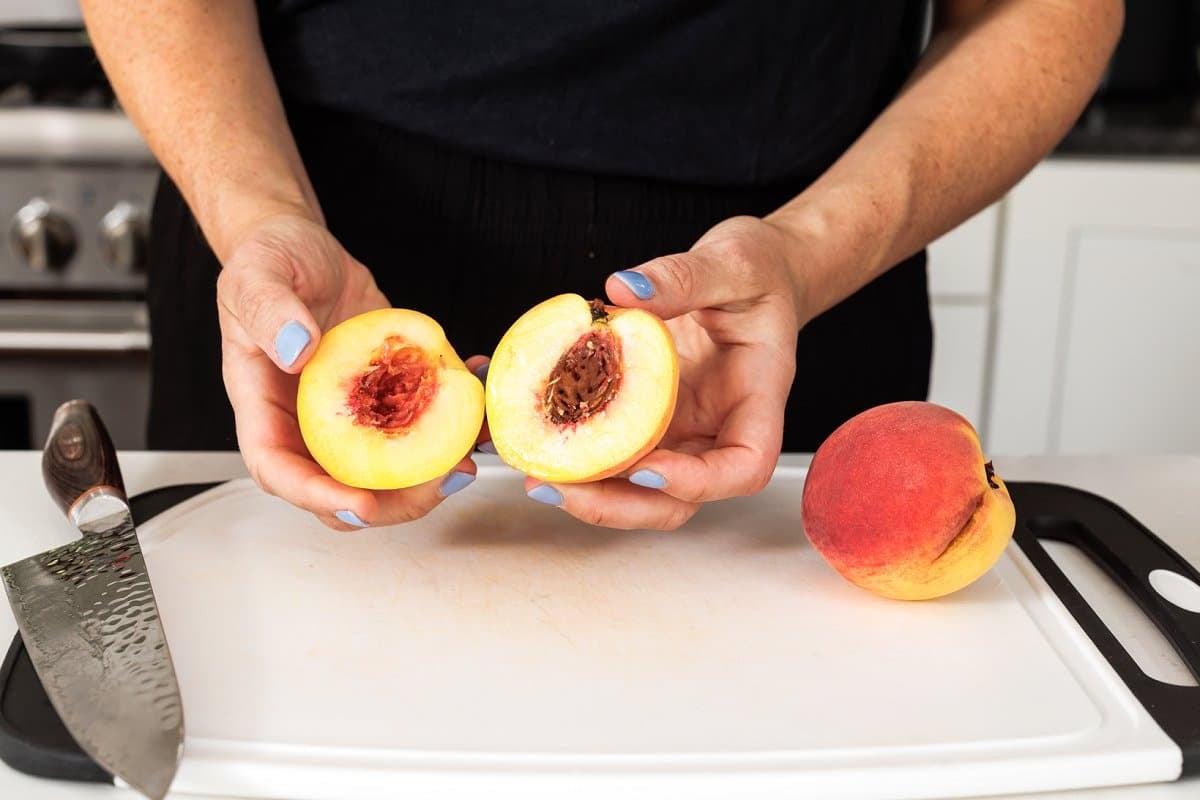 Liz cutting peaches on cutting board.
