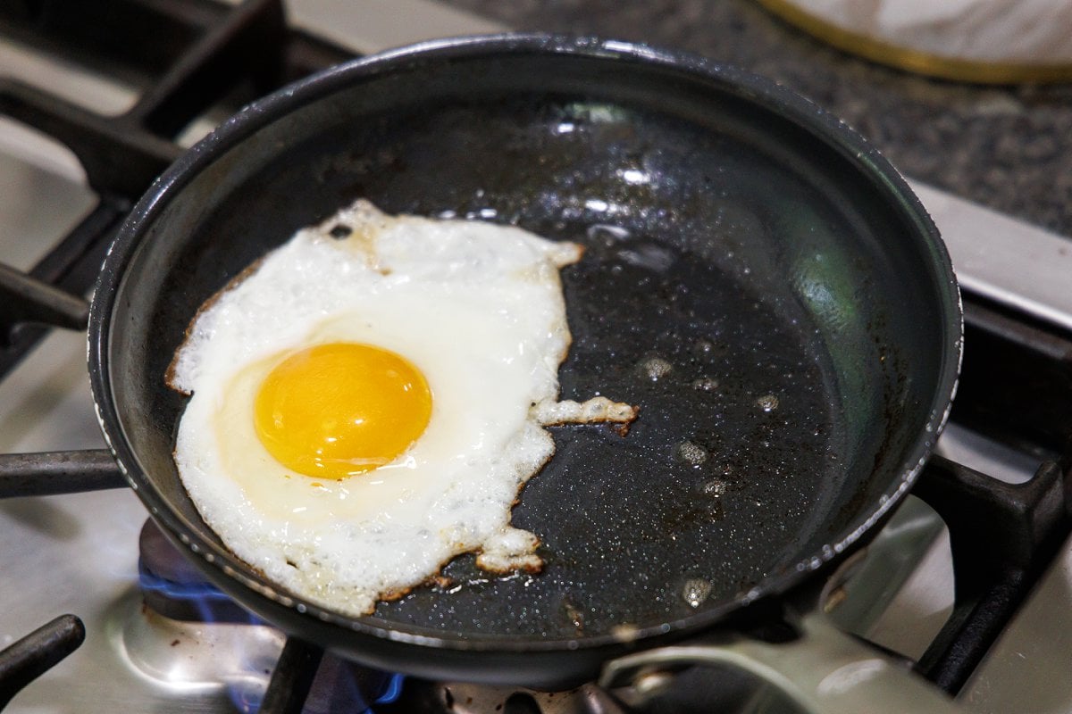 Frying an egg in a pan.