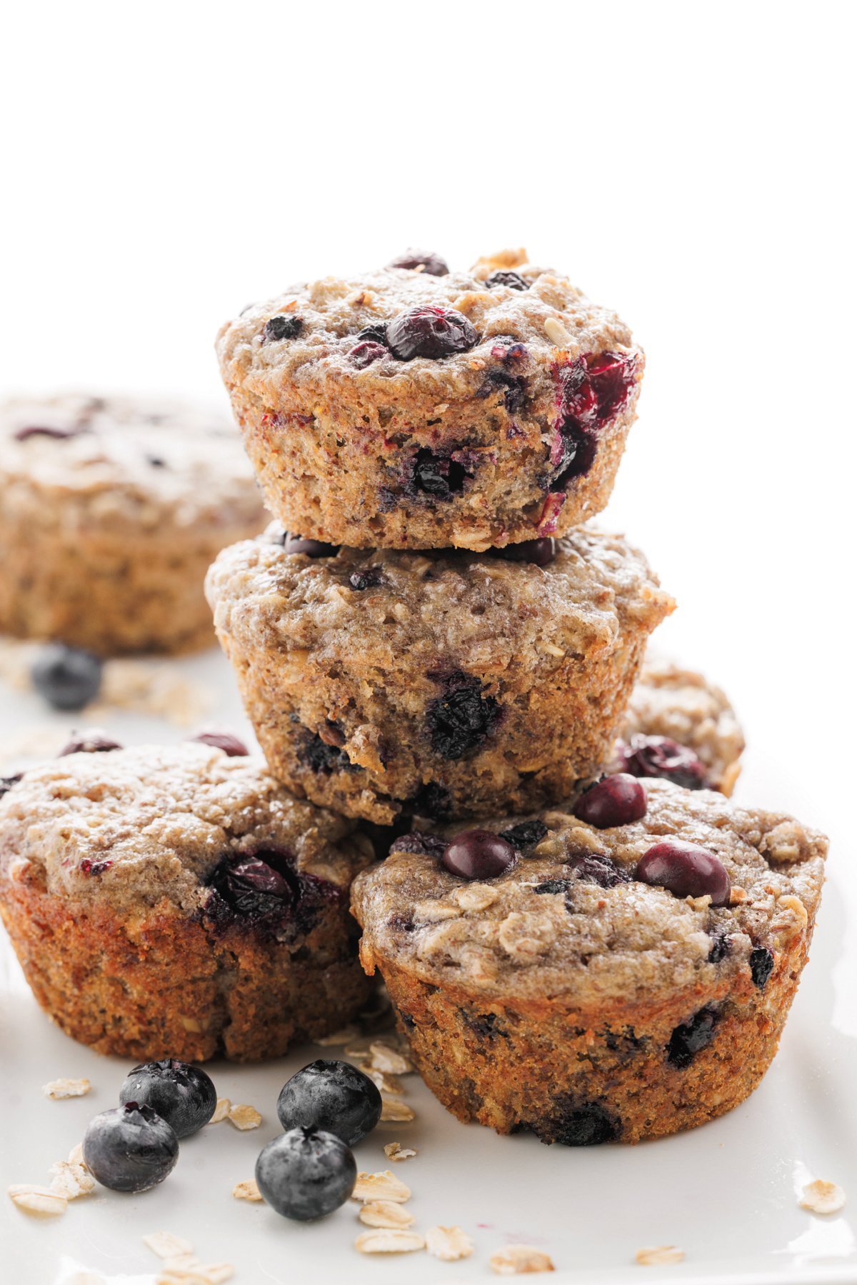 A stack of blueberry banana flaxseed muffins on a plate.