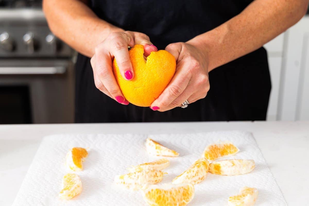 Liz peeling a clementine and separating the wedges.