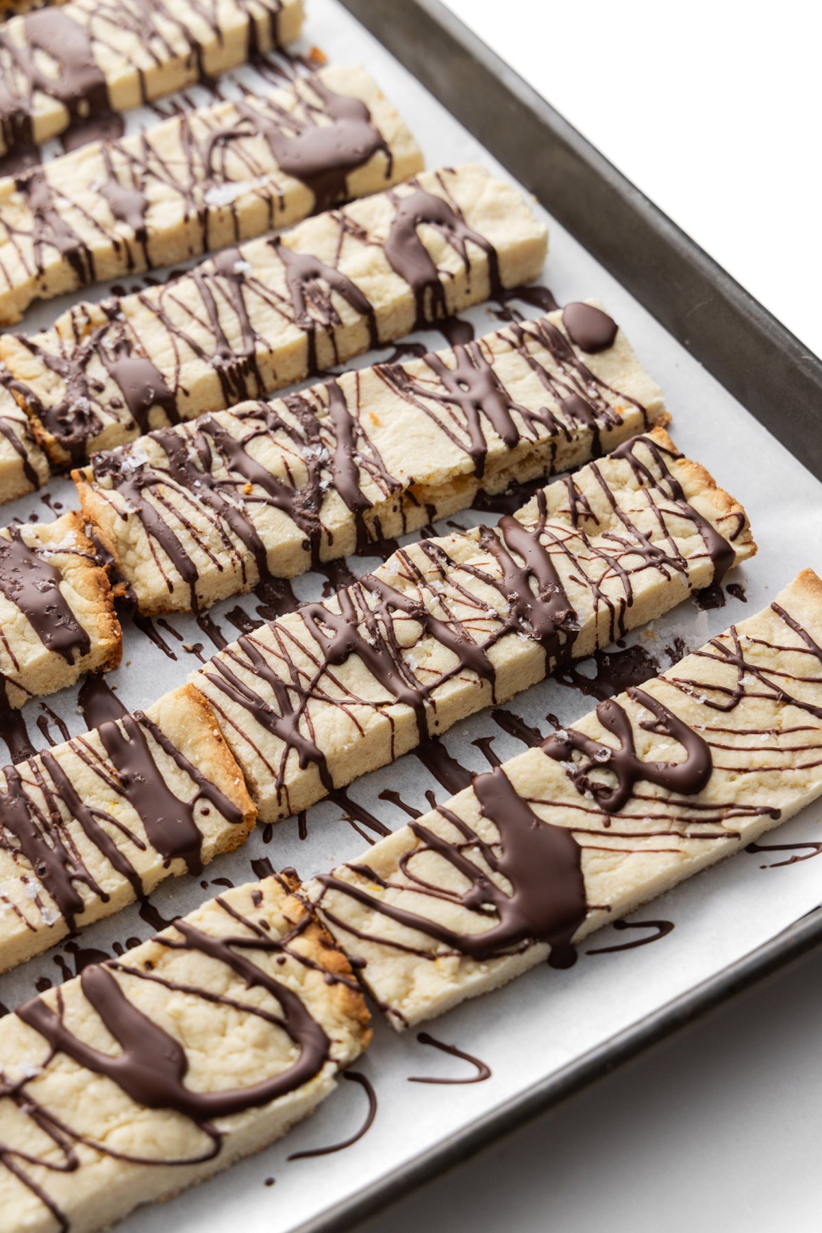 Tray of lemon shortbread cookies with chocolate drizzle.