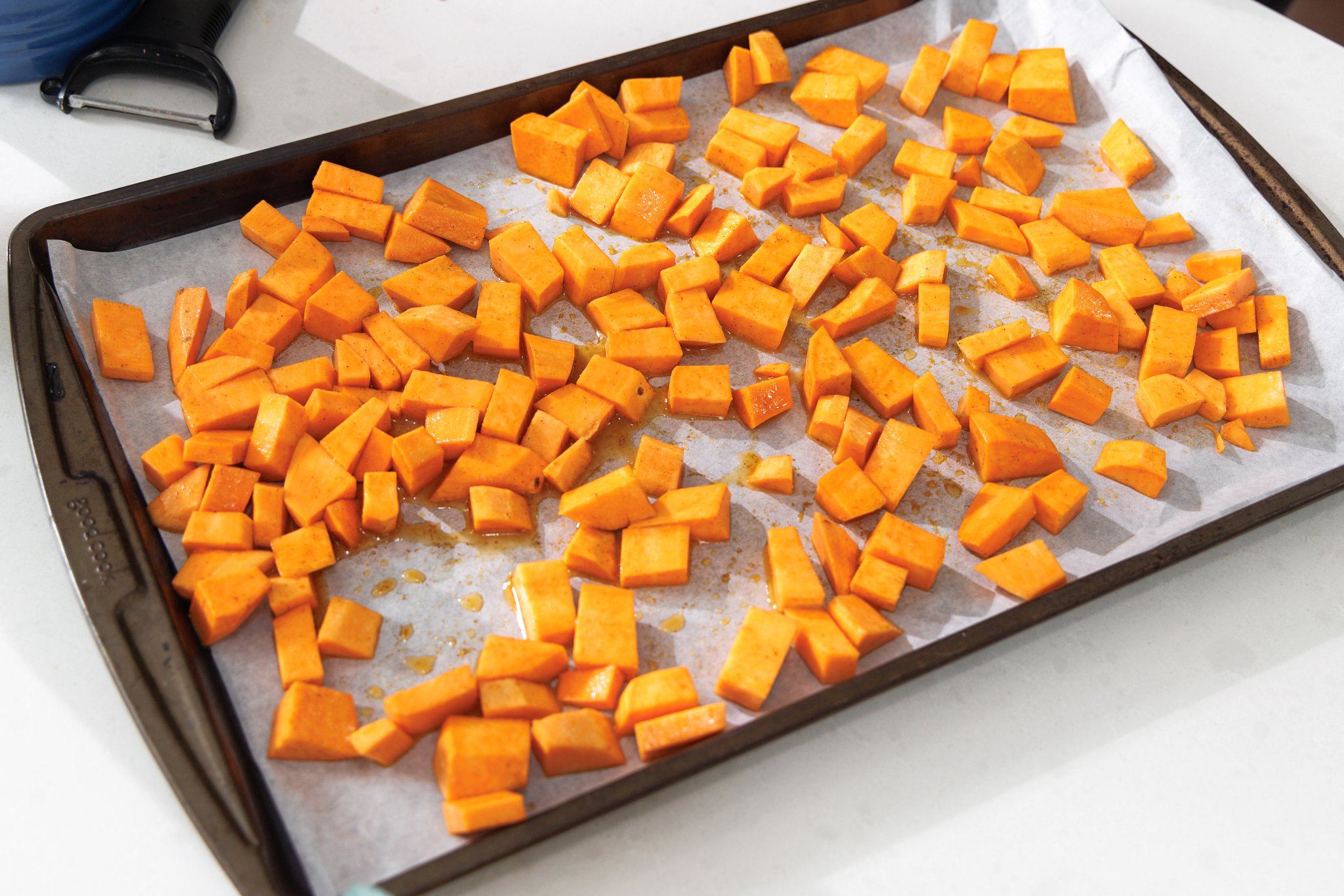 Laying sweet potatoes out on a baking sheet.