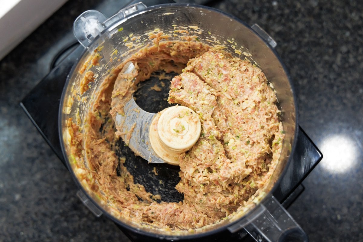 Mixing ground pork filling mixture in food processor.
