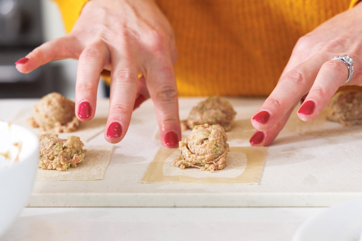 Wetting edges of wonton wrapper with wet fingers.